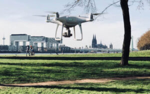 Eine Drohne fliegt über einer Wiese die rechte Rheinseite